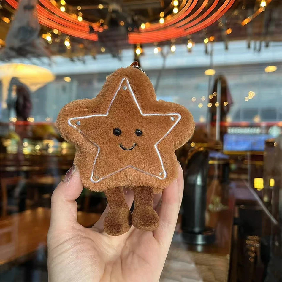 Jellycat. Star-shaped plush toy held in a hand with a blurred indoor background