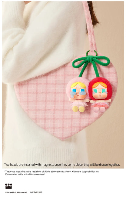 Pop Mart Cry Again Series, love you cherry much. Pink heart-shaped product with cartoon character heads on a beige background