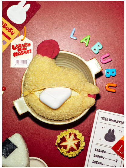 Labubu earphone case in a bowl with colorful 'Labubu' letters on a red background