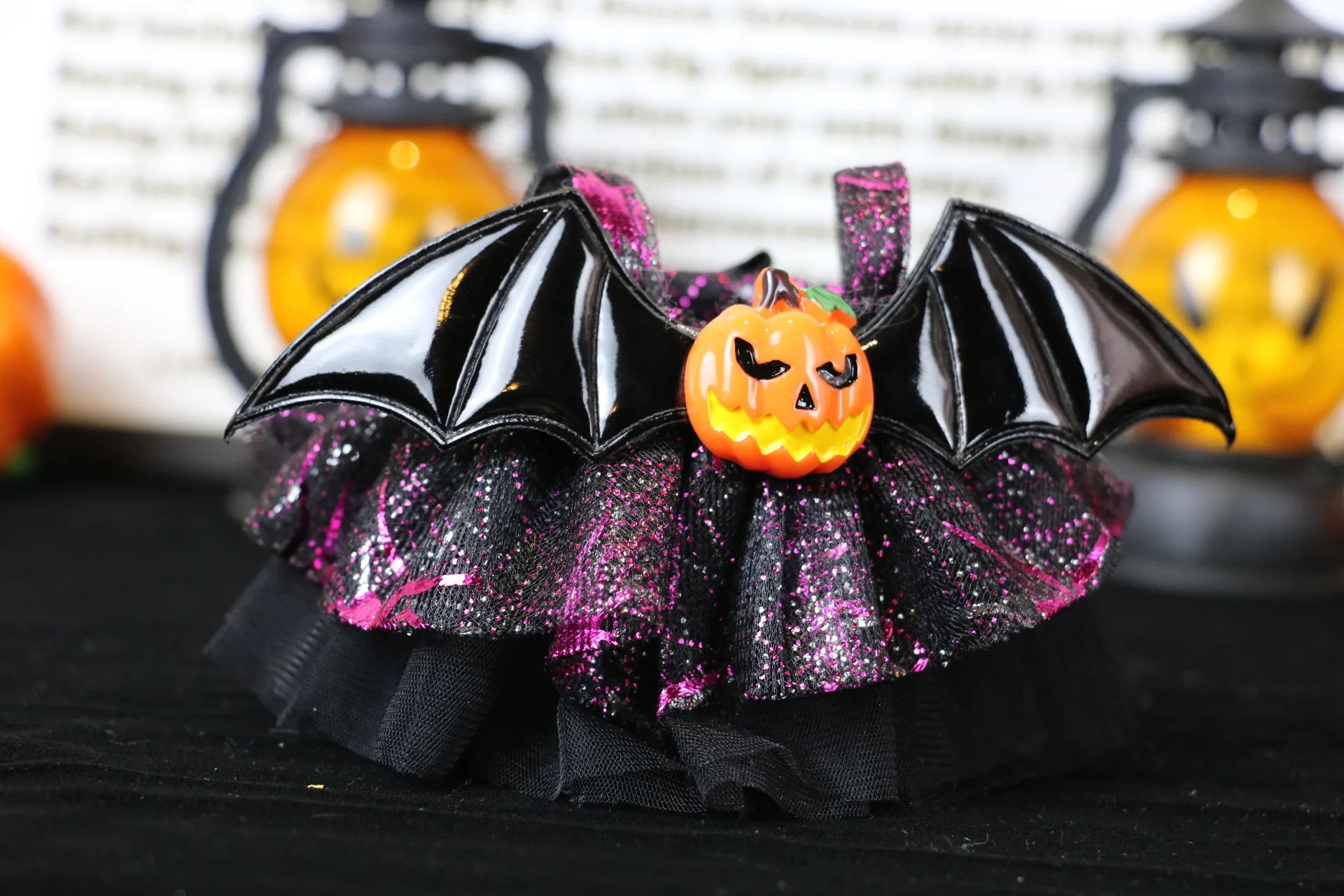 Labubu Halloween dress. Halloween-themed decorative item with bat wings and pumpkin on a black background