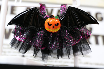 Labubu Halloween dress. Halloween-themed decorative item with bat wings, pumpkin, and tulle skirt on a white background