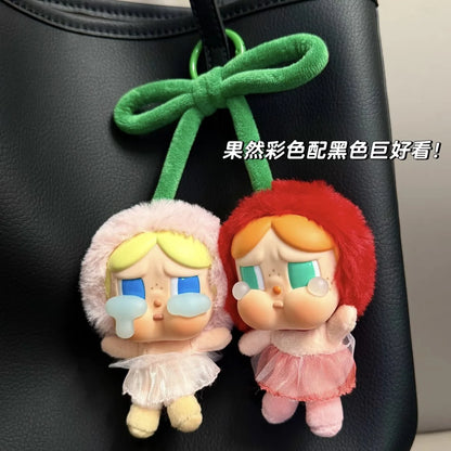 Pop Mart Cry baby, love you cherry much.Two cartoon character keychains with colorful hair on a black surface.