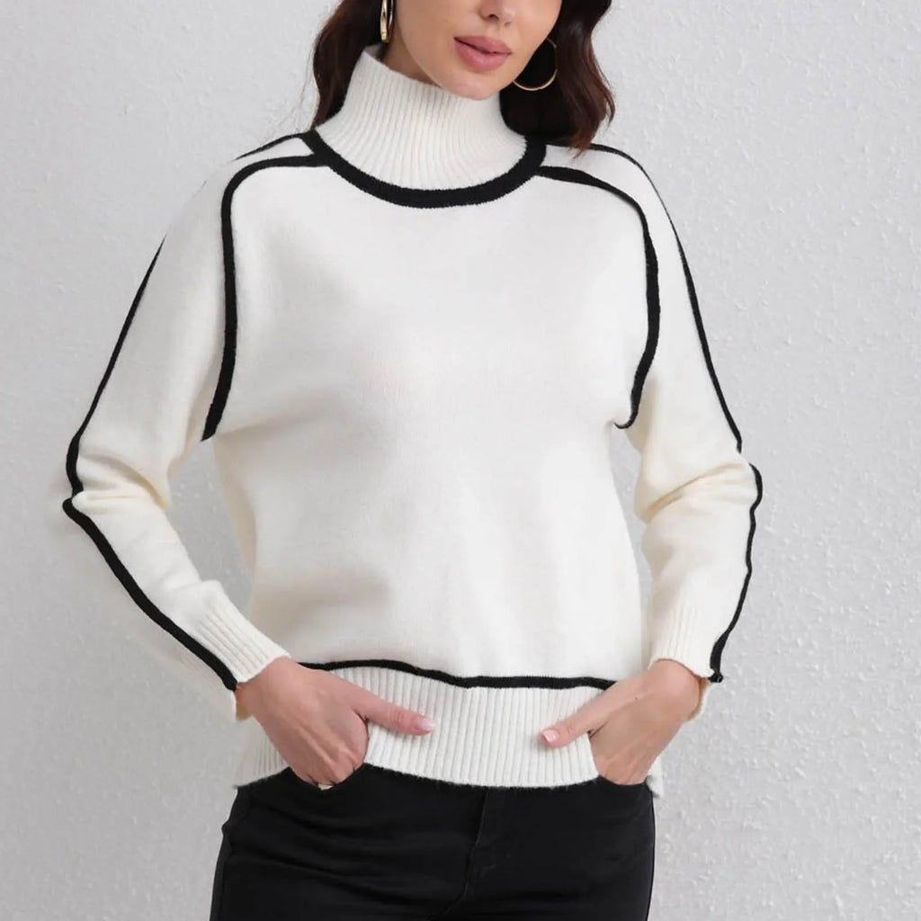 White sweater with black trim worn by a person against a plain background