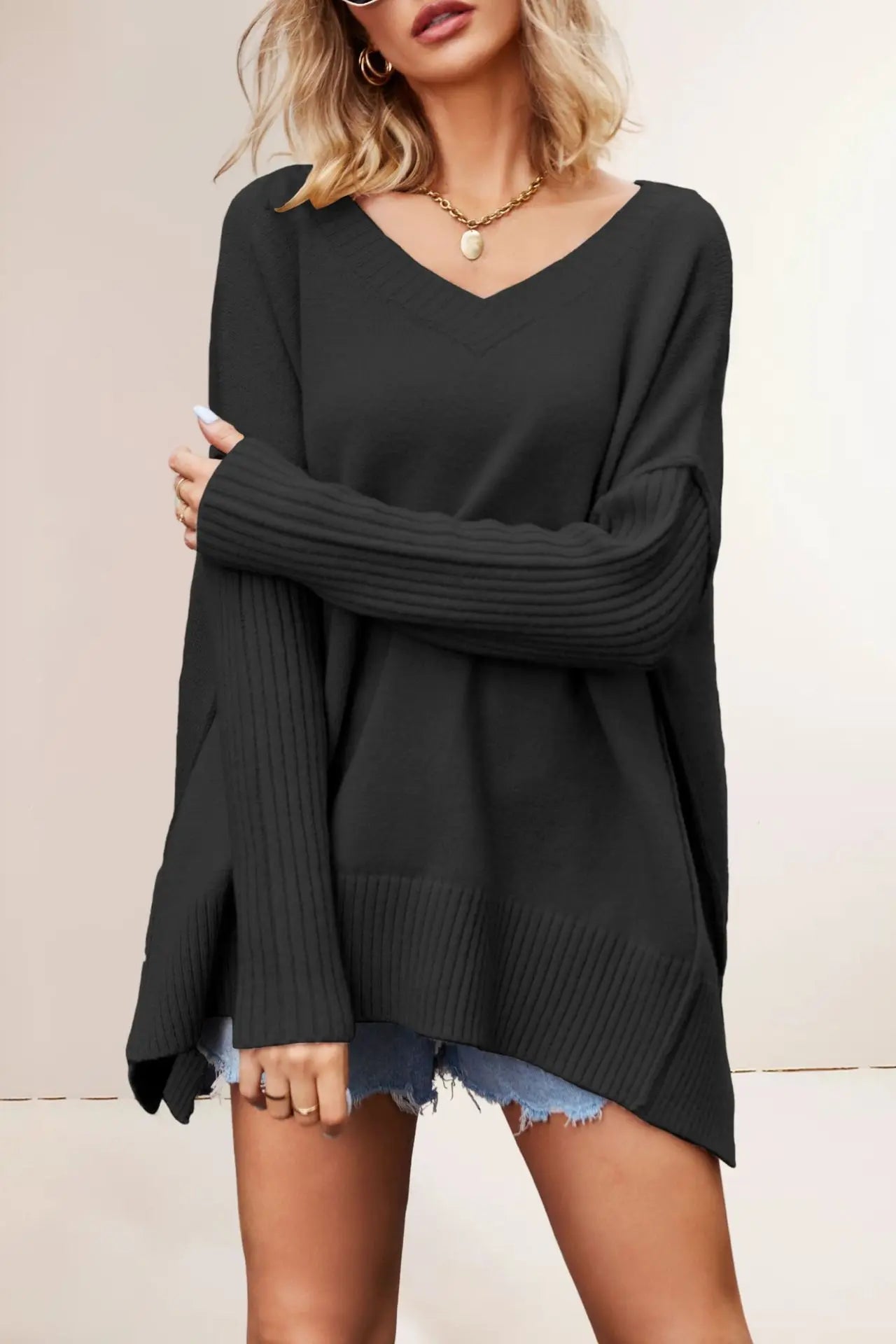 Woman wearing a black sweater with a plain background
