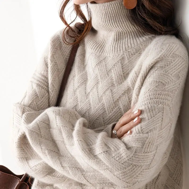 Close-up of a person wearing a beige turtleneck sweater with a blurred background