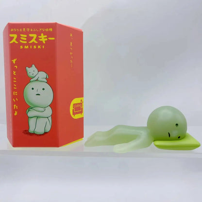 Smiski, living room series. Green plush toy with a red box featuring 'Smiski' branding on a white background