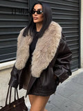 Woman wearing a black leather jacket with a fur collar in an urban setting.