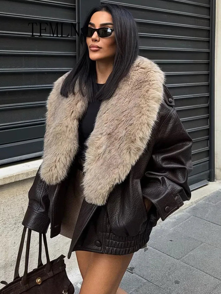 Woman wearing a black leather jacket with a fur collar in an urban setting.