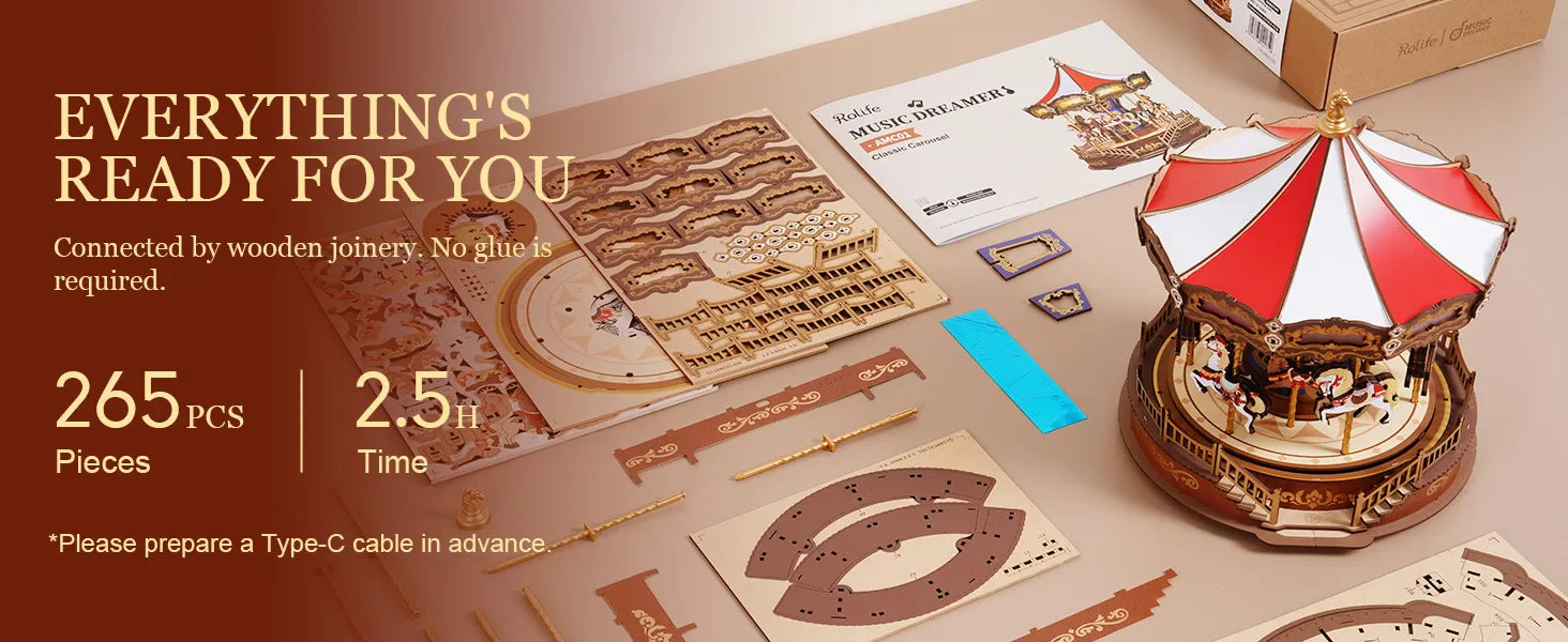 Wooden carousel model kit with packaging and components on a table.
