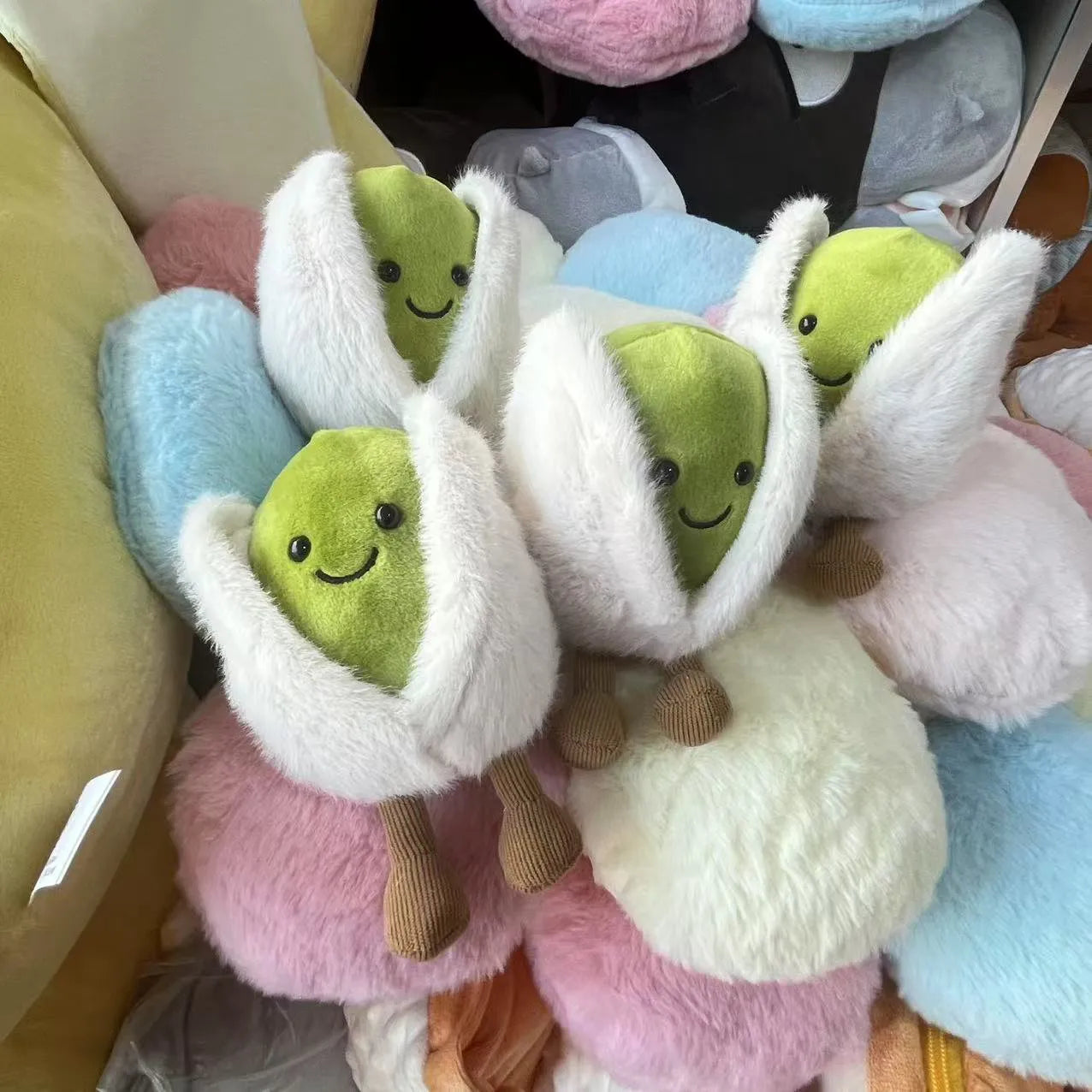  pistachio. Plush toys shaped like green characters with white sleeves in various colors.