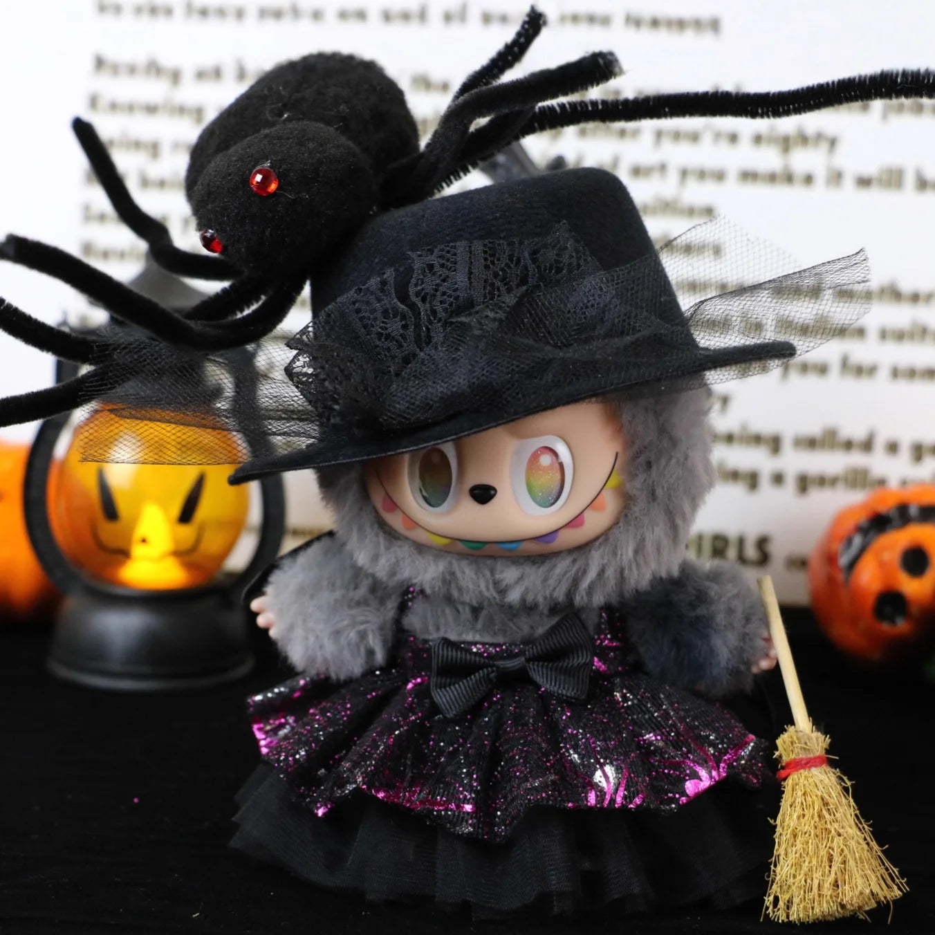 Labubu Halloween dress. Halloween-themed doll with spider, broom, and pumpkins on a text background