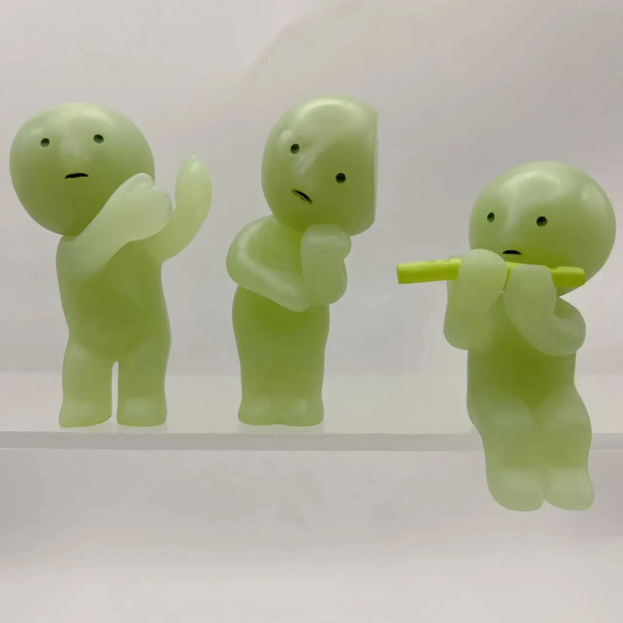 Smiski, living room series. Three green plastic figures on a white background