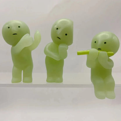Smiski, living room series. Three green plastic figures on a white background