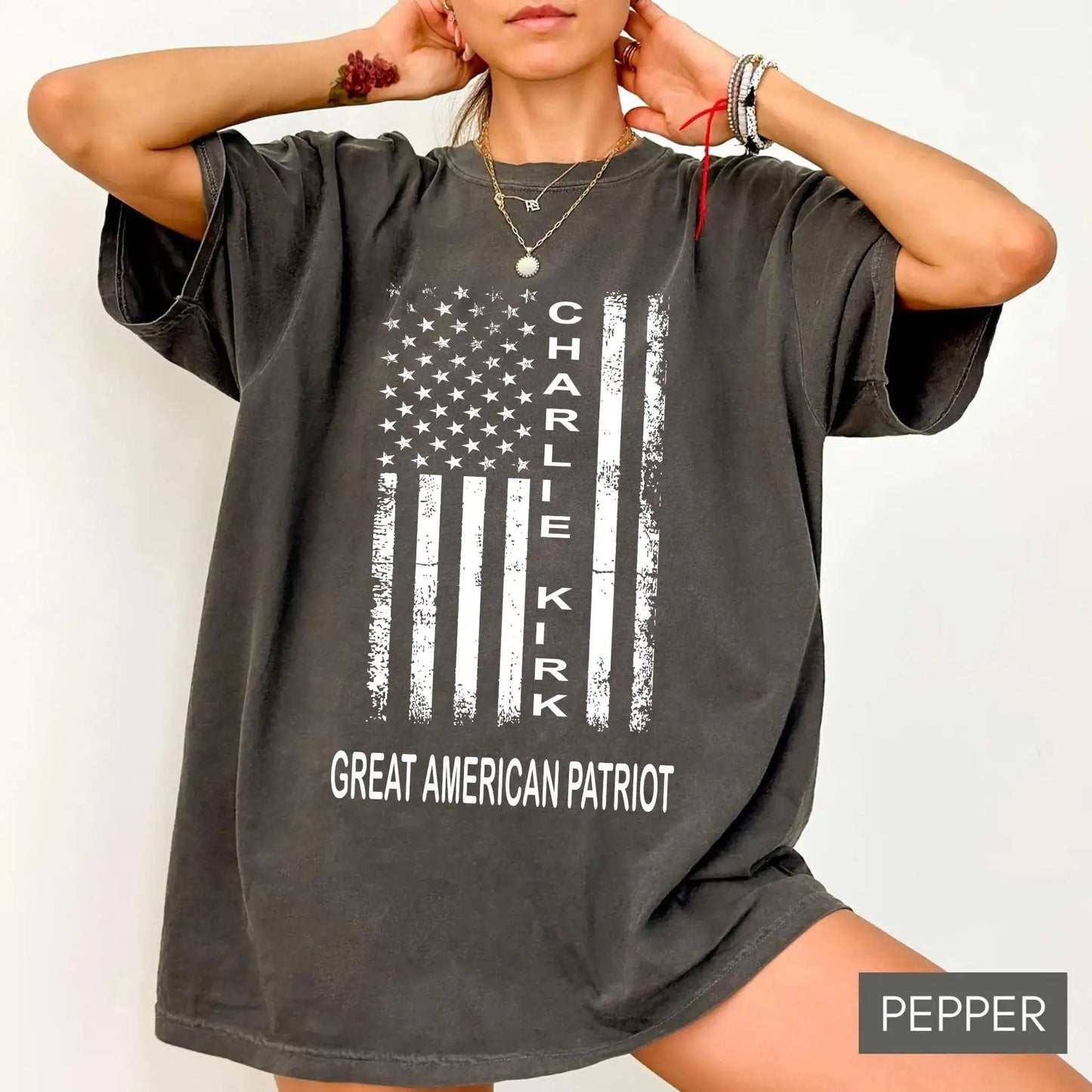 Person wearing a gray t-shirt with 'Charlie Kirk' and 'Great American Patriot' text on a white background