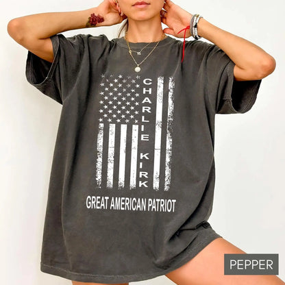 Person wearing a gray t-shirt with 'Charlie Kirk' and 'Great American Patriot' text on a white background