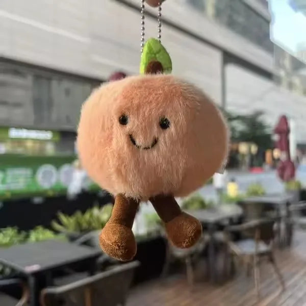  Plush keychain shaped like a cartoonish bread roll with a blurred outdoor background