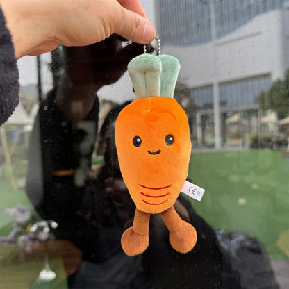 Jellycat carrot. Plush carrot keychain held by a hand with a blurred outdoor background