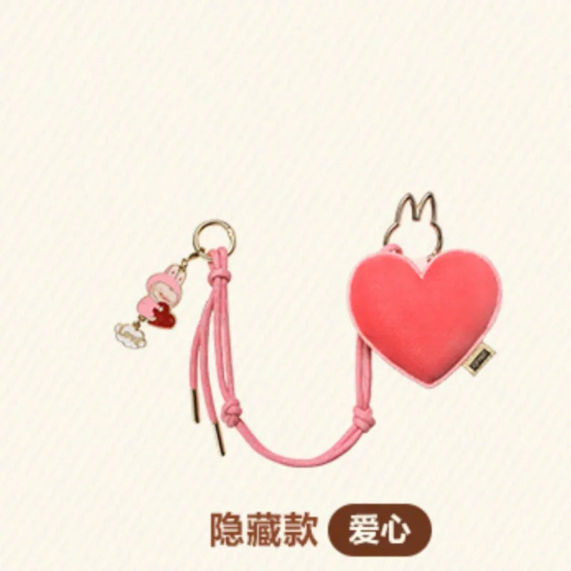 Labubu Pin for Love. Heart-shaped keychain with pink strap on a beige background