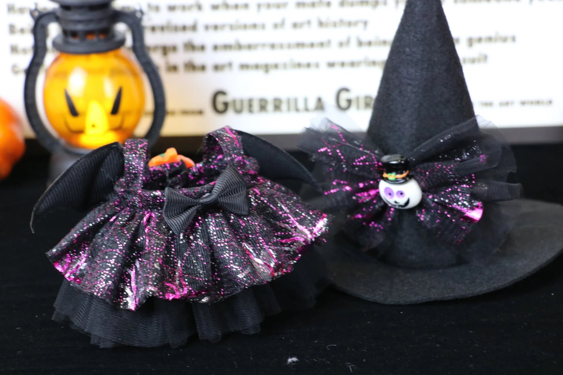 Labubu Halloween dress. Black glittery Halloween pet collar and witch hat with decorative elements on a dark background.