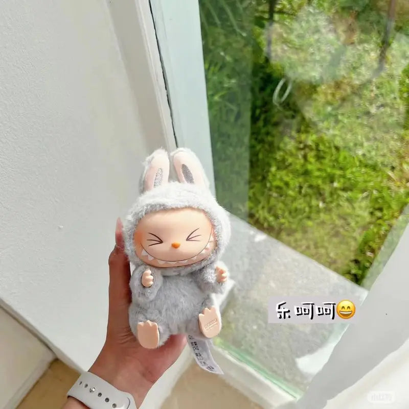 Plush toy Labubu held by a hand with a window in the background