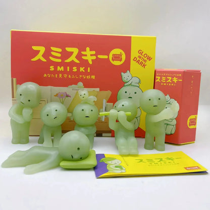 Green Smiski figures with packaging on a white background