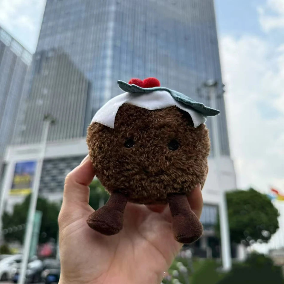 Jellycat. Plush toy resembling a brownie with a white topping held in front of a cityscape.
