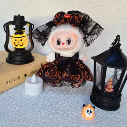 Halloween-themed Labubu with black lace dress and pumpkin lanterns on a light blue surface.
