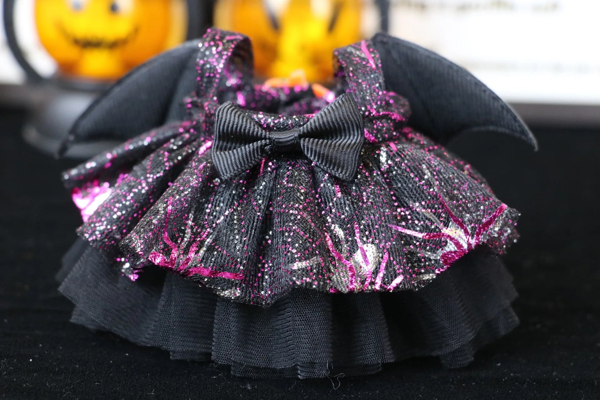Labubu Halloween dress. Black and pink glittery pet dress with a bow on a dark background