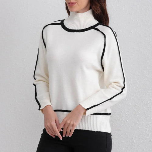 White sweater with black trim worn by a person on a light gray background